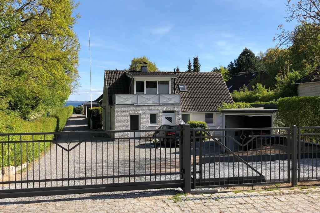 a fence in front of a house with a driveway at Flipper in Sierksdorf