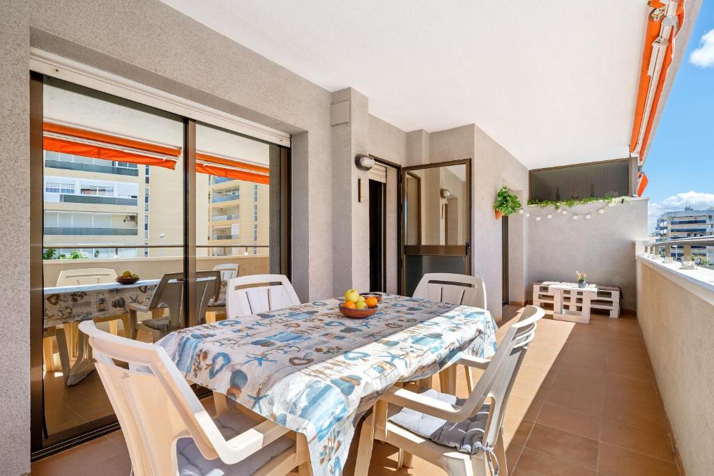 Un comedor con mesa y sillas en un balcón. en Apartamento Familiar en la Pineda, en La Pineda