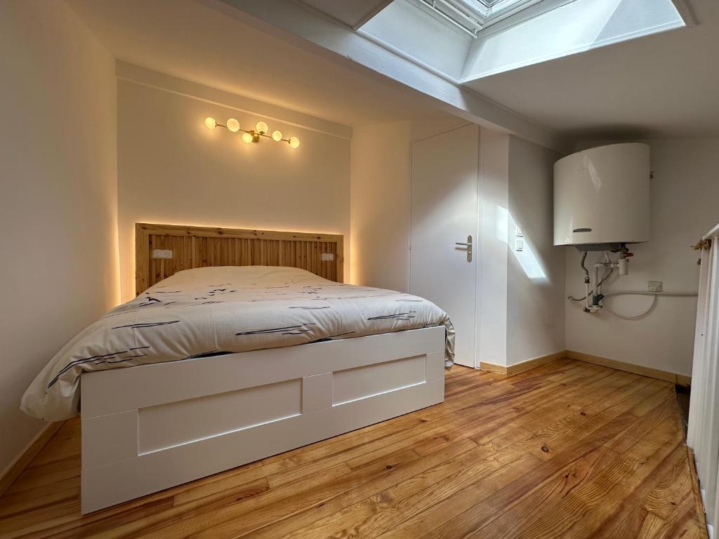 une chambre avec un lit et une lucarne dans l'établissement Le Ramblas Jean Jaures Matabieu, à Toulouse