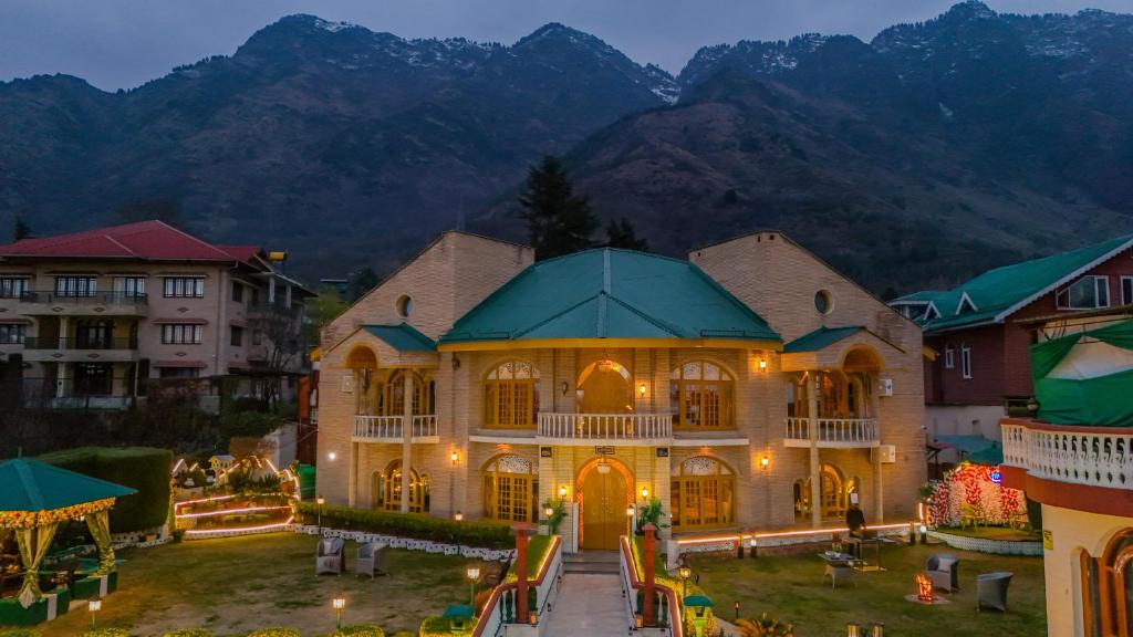 a large building in a city with mountains in the background at SaffronStays King Mahal in Srinagar