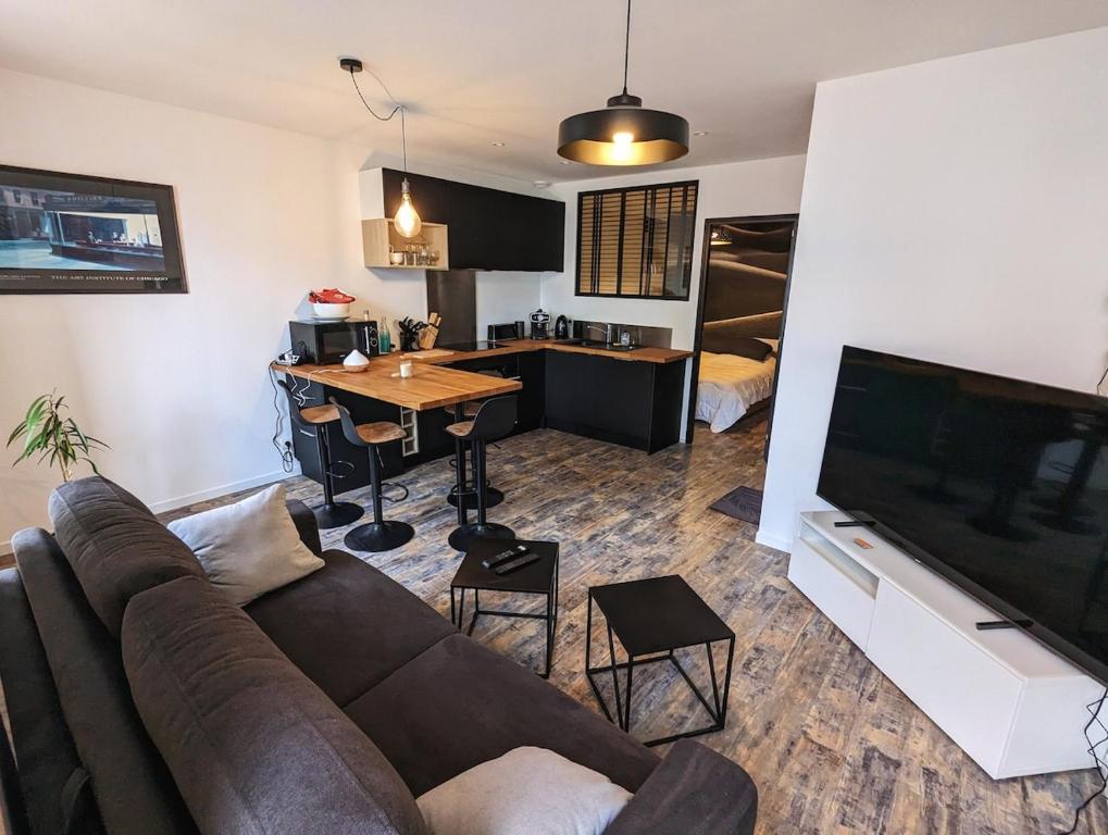 un salon avec un canapé et une table et une cuisine dans l'établissement Petit corbin, à Vannes