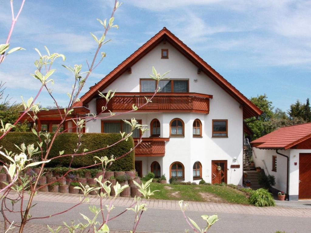 una casa blanca con techo rojo en Ferienwohnung Linder, en Schömberg