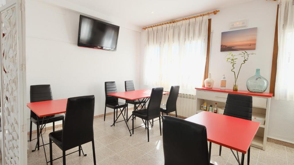 a dining room with red tables and black chairs at Hotel Paradís in Torredembarra