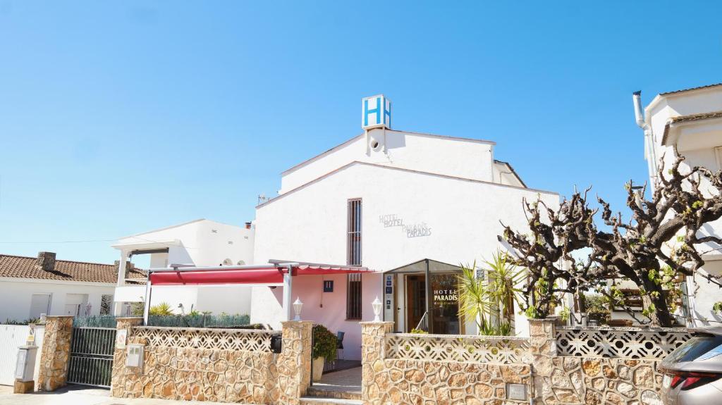 a white church with a fence in front of it at Hotel Paradís in Torredembarra