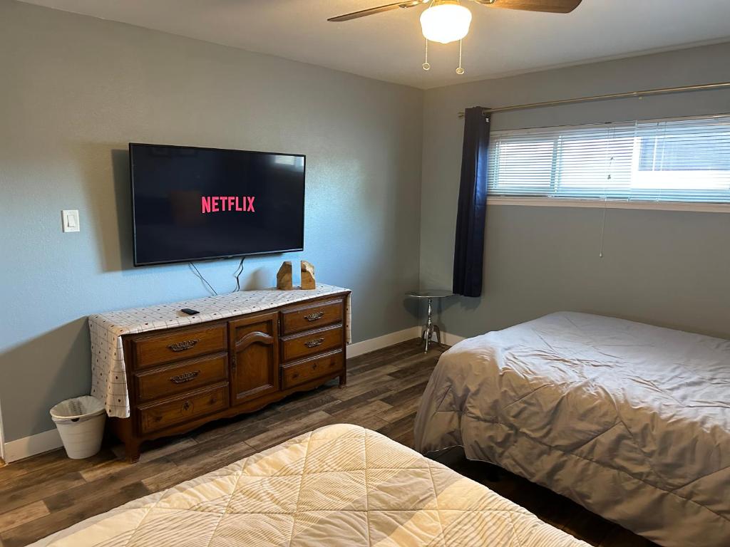 a bedroom with two beds and a flat screen tv at Casada in Las Vegas