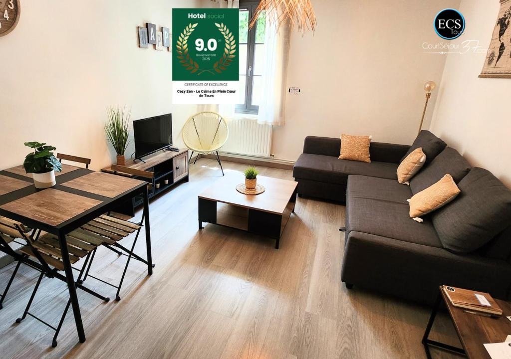 a living room with a couch and a table at "Cozy Zen" 1 grande chambre - Calme - Arrivée autonome - 6 pers - Parking gratuit in Tours
