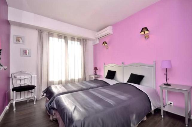 カンヌにあるAPPART' CANNESの紫色のベッドルーム(大型ベッド1台付)