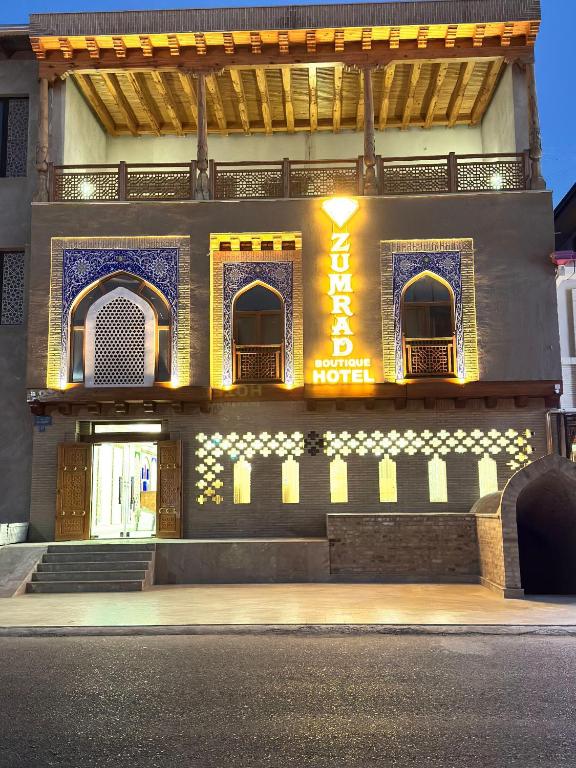 a building with a sign on the side of it at Zumrad Boutique Hotel in Bukhara