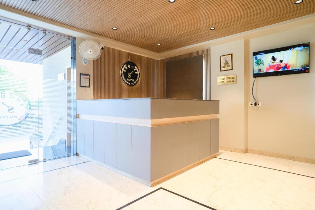 a lobby with a counter and a tv on the wall at HOTEL SNOOZE in Jaipur