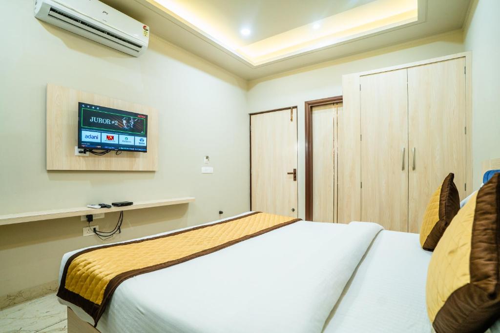 a bedroom with a bed and a tv on the wall at HOTEL SNOOZE in Jaipur