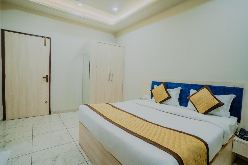 a bedroom with a large bed with blue and gold pillows at HOTEL SNOOZE in Jaipur