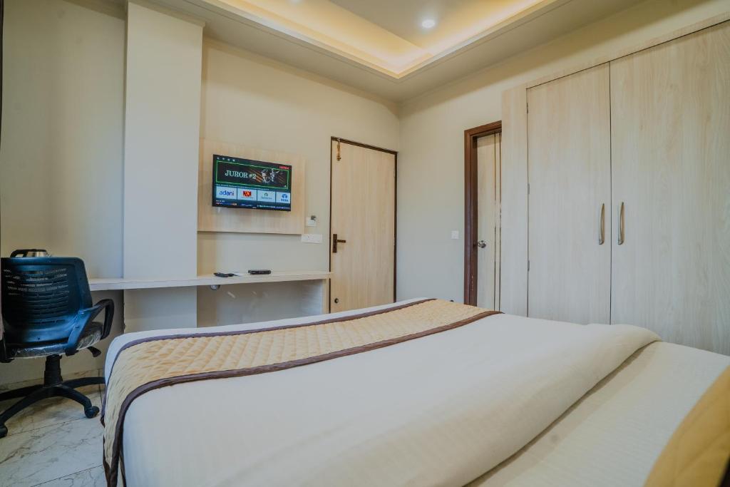 a bedroom with a bed and a desk and a chair at HOTEL SNOOZE in Jaipur
