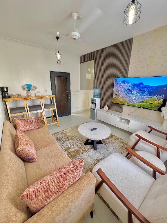 a living room with a couch and a flat screen tv at Majestic Haven Suite in Mombasa