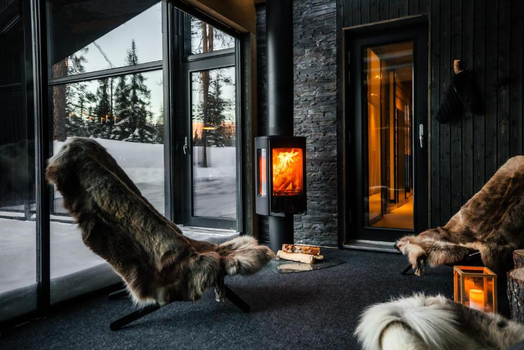 two dogs are standing in front of a fireplace at Villa Laponia - Borealis in Äkäslompolo