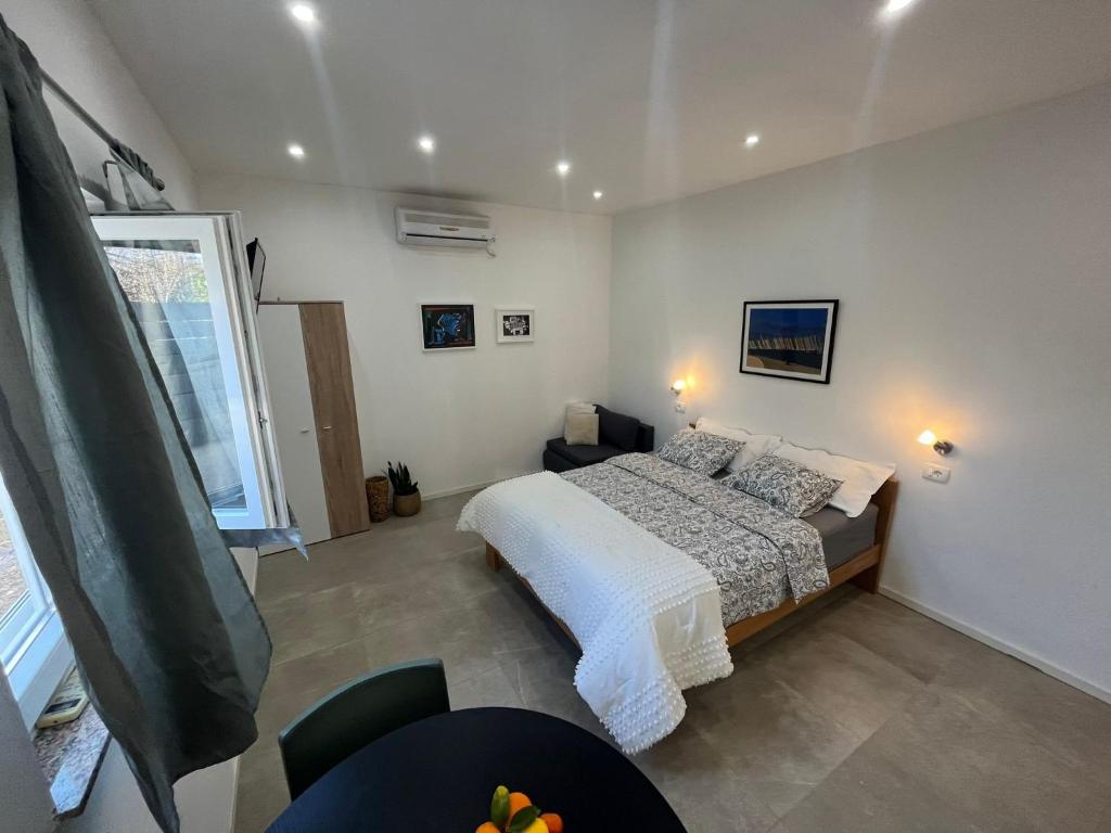 a bedroom with a bed and a table and a window at Apartments Fishers in Vodice