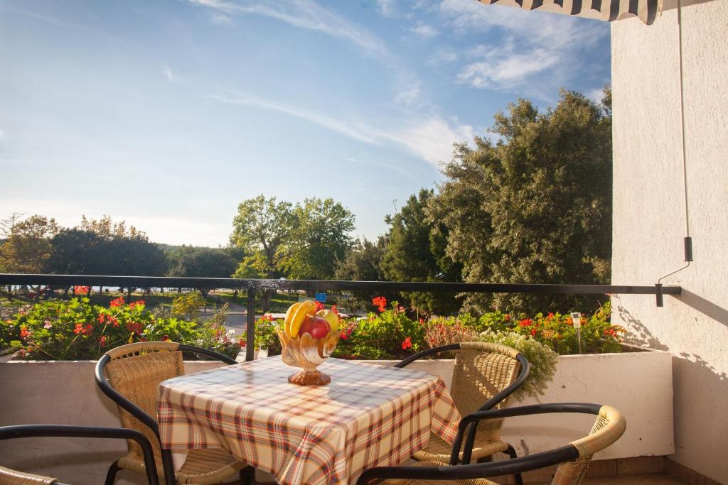 a table with chairs and a vase on a balcony at Two Bedroom Apartment Sonja with Seaview in Punat