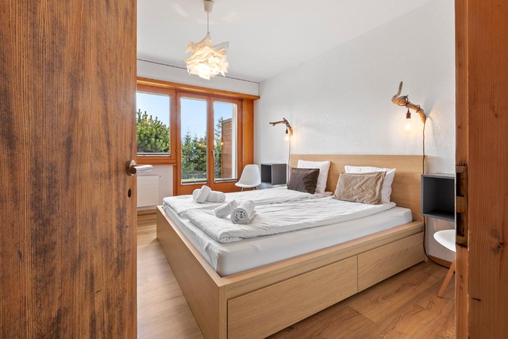 ein Schlafzimmer mit einem großen Bett mit weißer Bettwäsche in der Unterkunft Appartement avec terrasse, proche du centre in Crans-Montana