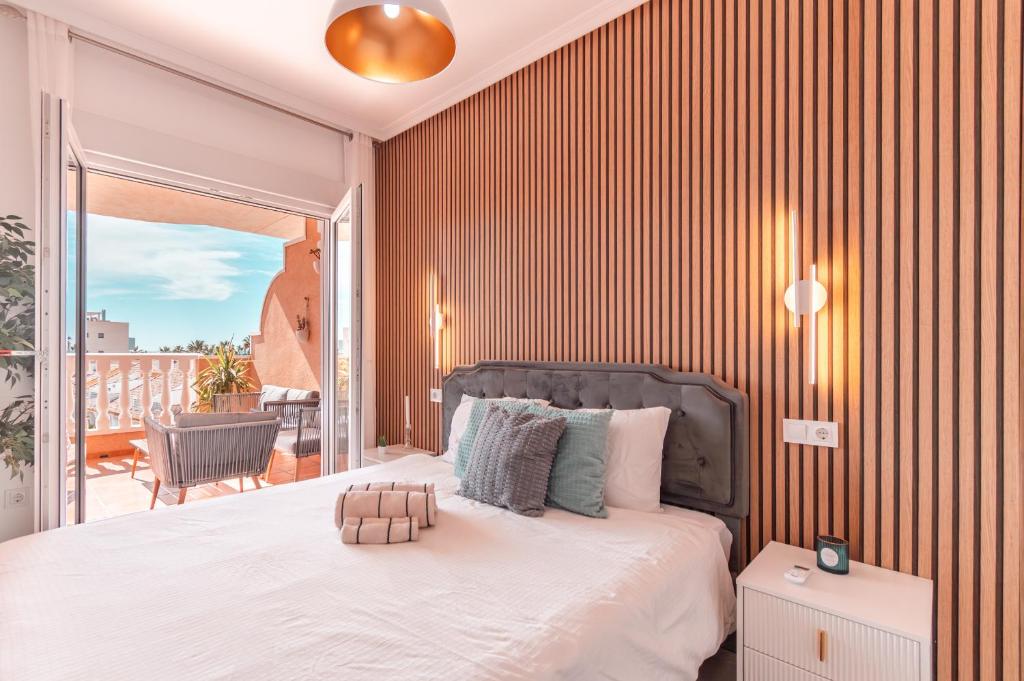 a bedroom with a large bed and a balcony at Design Seascape apartment in Orihuela Costa