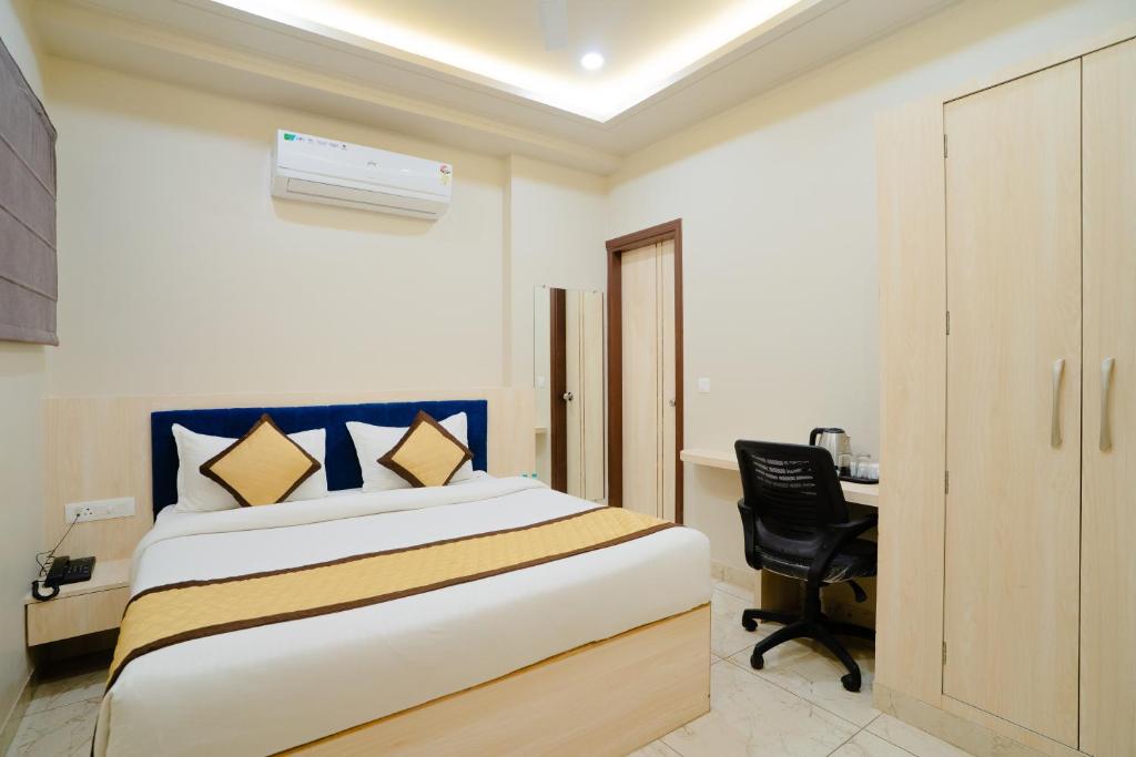 a bedroom with a bed and a desk with a chair at HOTEL SNOOZE in Jaipur