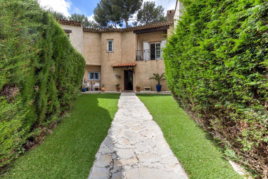 une image d'une maison entre deux grands haies dans l'établissement Villa in Antibes domain with tennis and pools, à Antibes