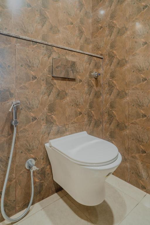 a bathroom with a white toilet in a tiled wall at HOTEL SNOOZE in Jaipur