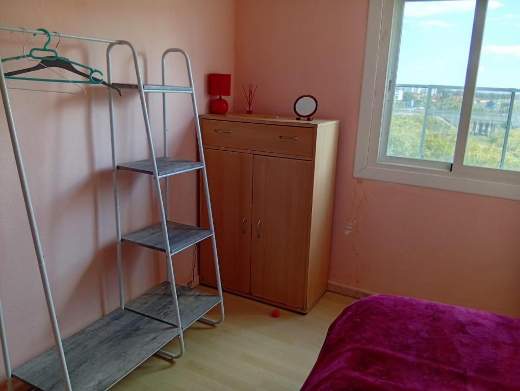 - une chambre avec une échelle, un lit et une fenêtre dans l'établissement La casa de Luda, à San Vicente del Raspeig