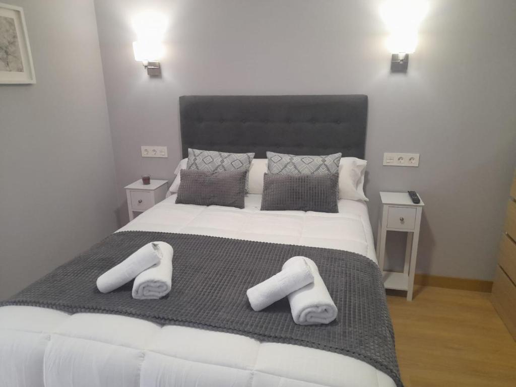 a bedroom with a large bed with two white pillows at APARTAMENTOS CASA FREDI - Apartamentos les cuartes 1 y 2 in Cardes