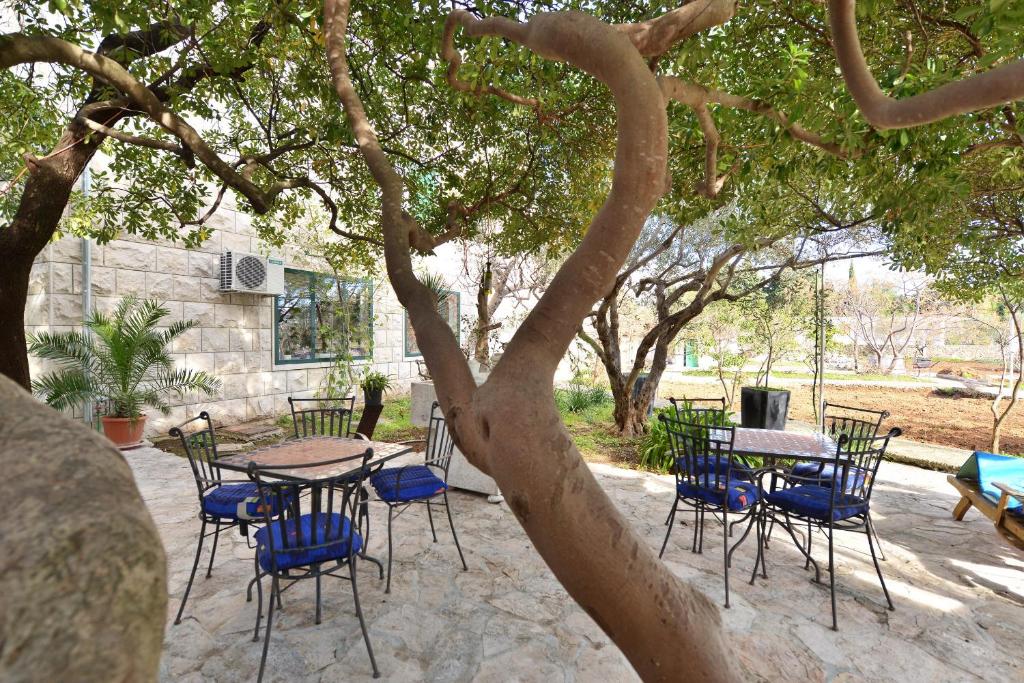 un groupe de tables et de chaises sous un arbre dans l'établissement Apartments Franka, à Sumartin
