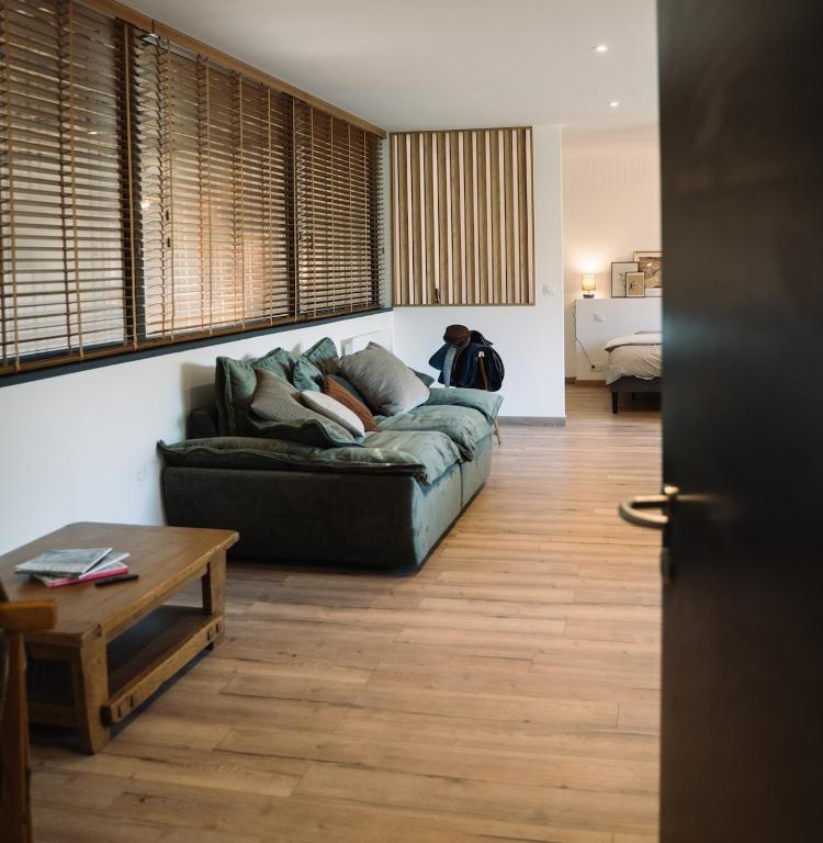 une personne assise sur un canapé dans un salon dans l'établissement Cavalier Loft Domaine de Greffeil, à Greffeil
