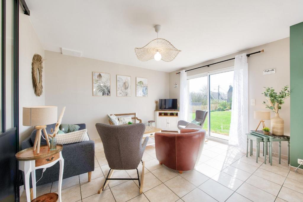 a living room with a couch and chairs and a table at Maison pour 6 avec jardin à 500 m de la plage in Lilia