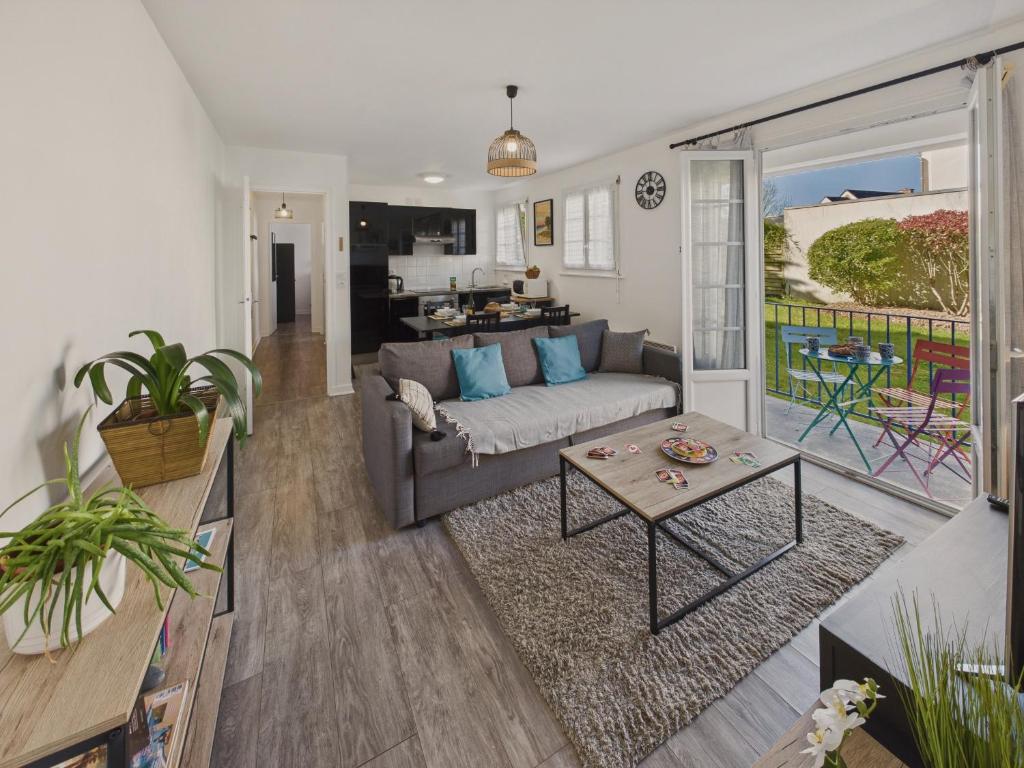 un salon avec un canapé et une table dans l'établissement Appartement pour 4 à 5 minutes de la plage, à Loctudy