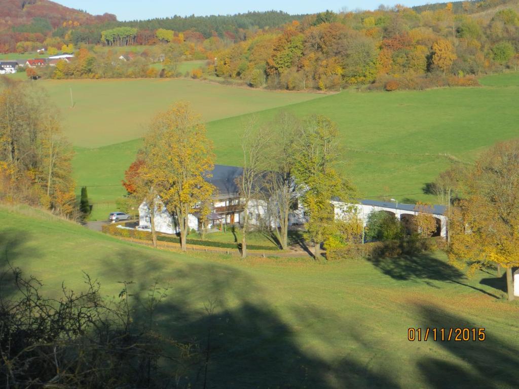 an aerial view of a house in a green field at Ferienwohnungen Grafenfelder Hof in Gerolstein