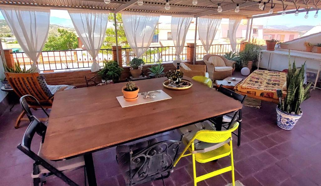 a table and chairs in a room with a balcony at Casa Amapola in Alhaurín el Grande