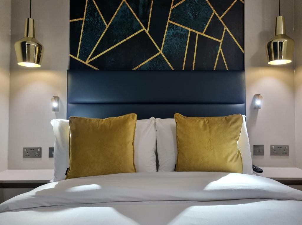 a bedroom with a bed with two yellow pillows at West Brompton Studios in London