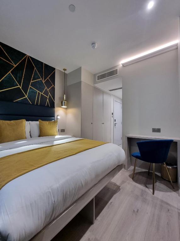 a bedroom with a large bed and a blue chair at West Brompton Studios in London