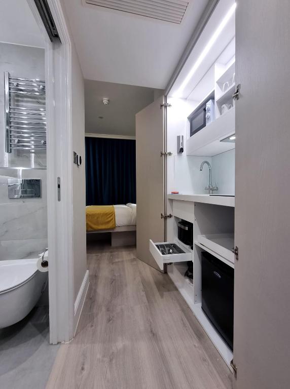 a bathroom with a tub and a sink and a bed at West Brompton Studios in London