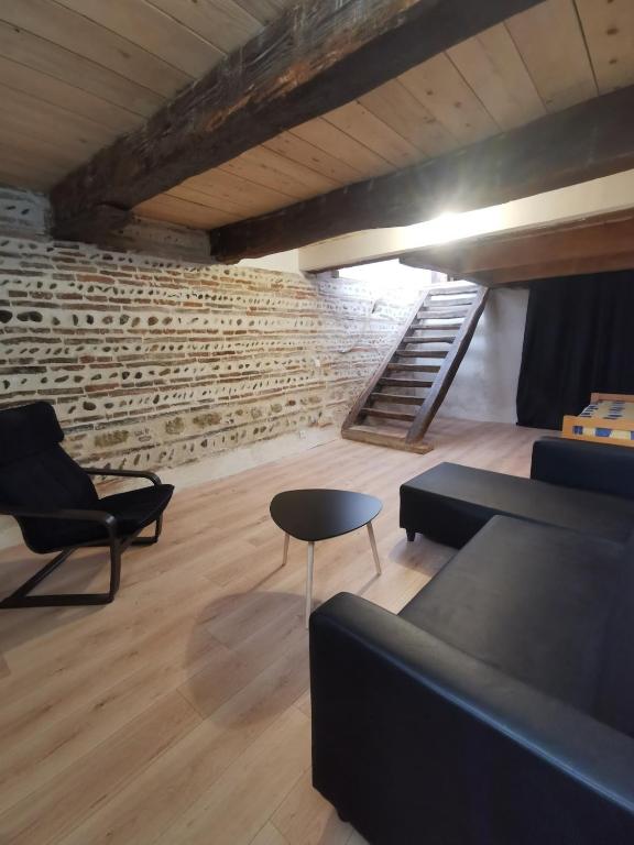 une chambre avec un canapé, une table et des escaliers dans l'établissement Maison au coeur du village, à Grenade