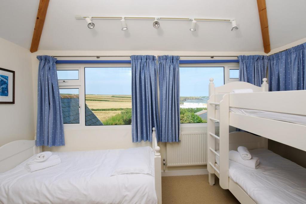 a bedroom with two bunk beds and a window at Cliff House, Cornwall in Padstow