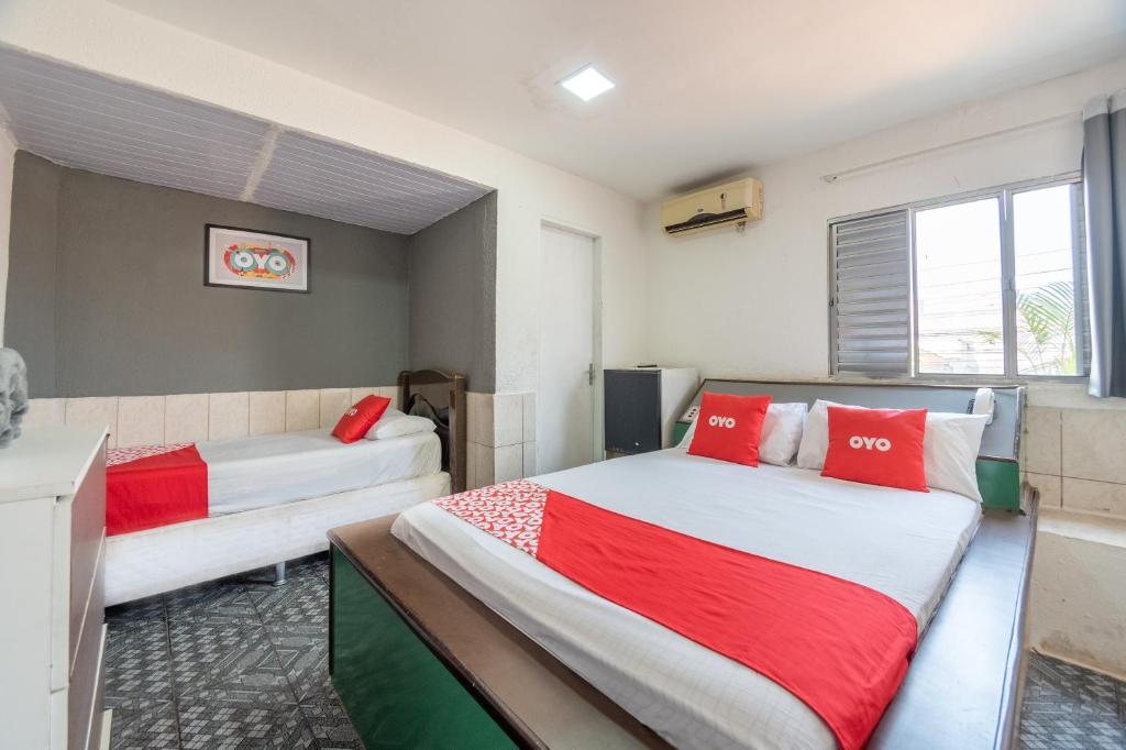 a bedroom with two beds with red and white pillows at OYO Nações Unidas, Sao Paulo in Sao Paulo