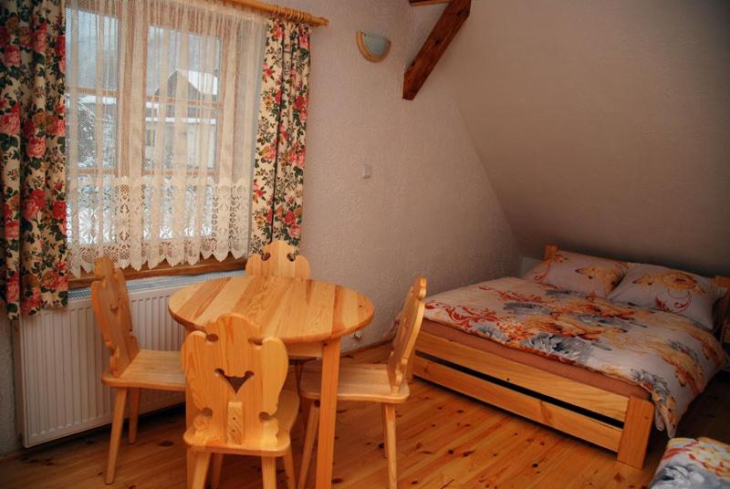 a bedroom with a bed and a table and chairs at Świerkowa Chata in Szczyrk