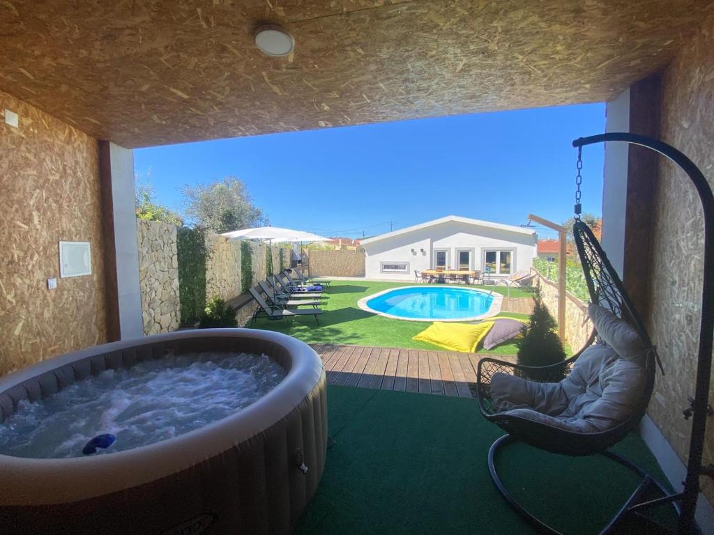 a backyard with a hot tub and a swing at Da Serra guesthouse in Porto de Mós