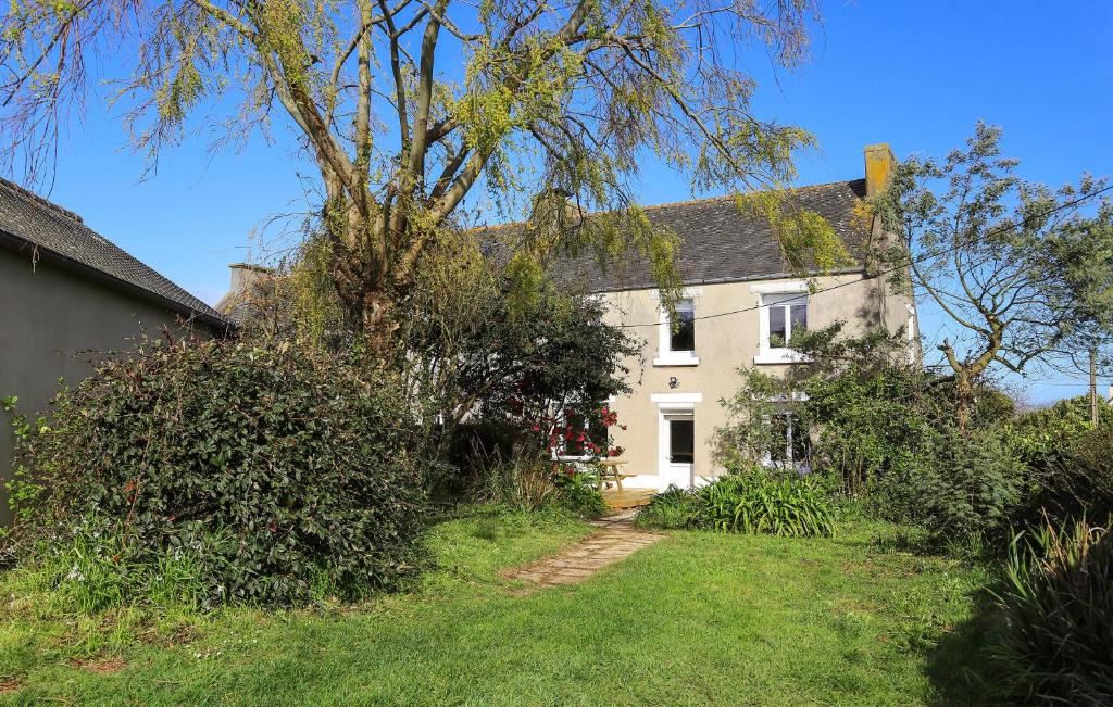 a white house with a tree in the yard at 3 Bedroom Stunning Home In Plougasnou in Plougasnou