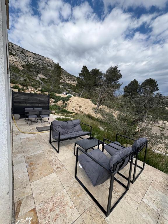 d'une terrasse avec deux canapés et une vue sur le désert. dans l'établissement Le Cassiopée, à Ensuès-la-Redonne