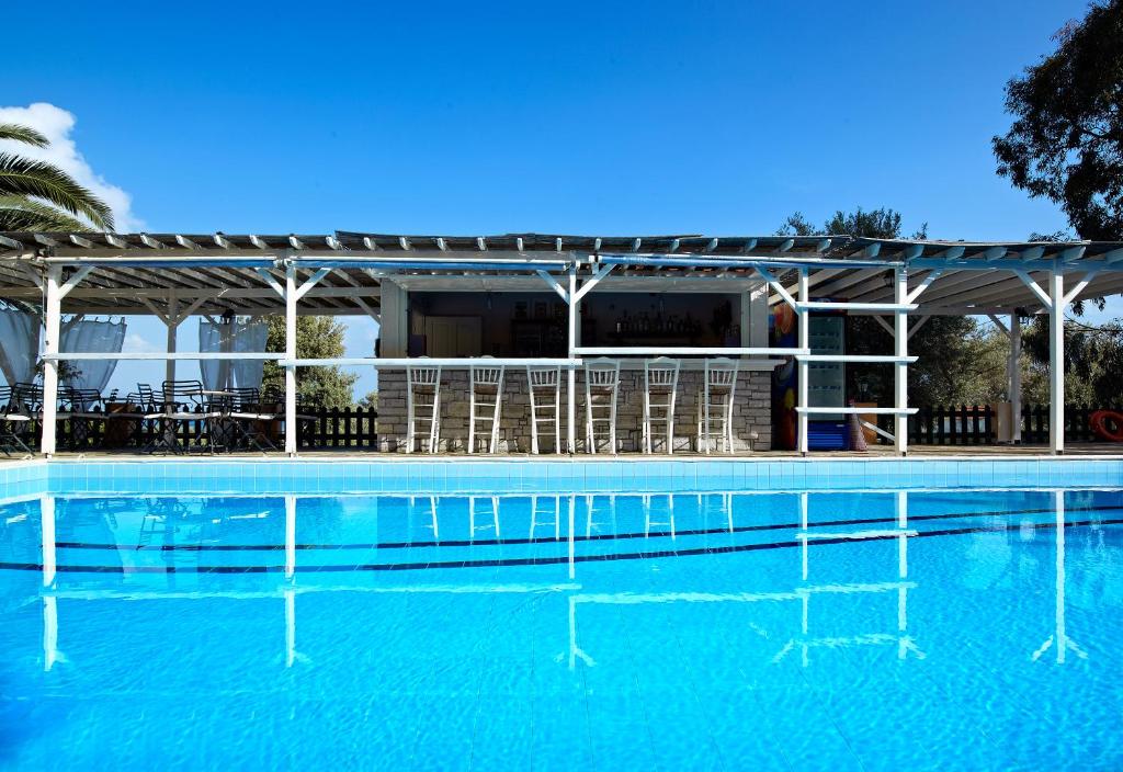 una gran piscina con sillas y un edificio en Hotel Ledra, en Marathokampos