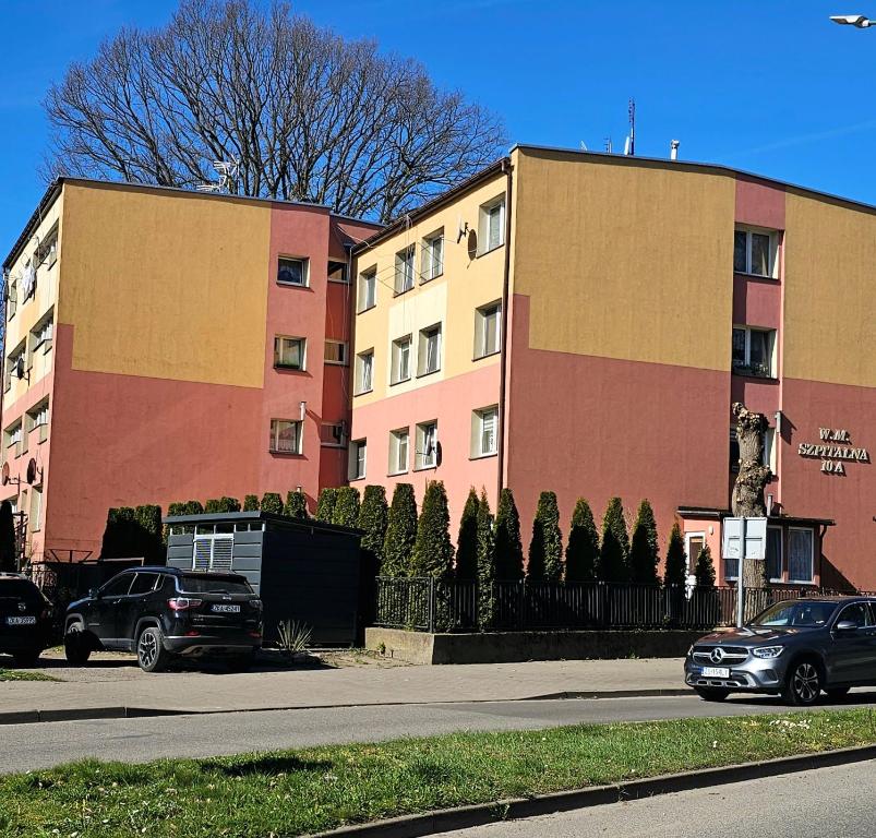 two buildings on the side of a street with parked cars at Apartament Mieszkanie Kamień Pomorski in Kamień Pomorski