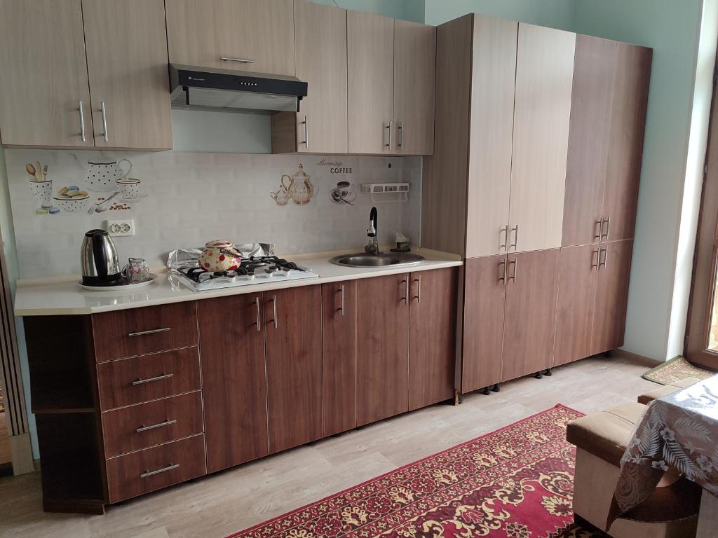 a kitchen with wooden cabinets and a sink in it at Квартира in Samarkand