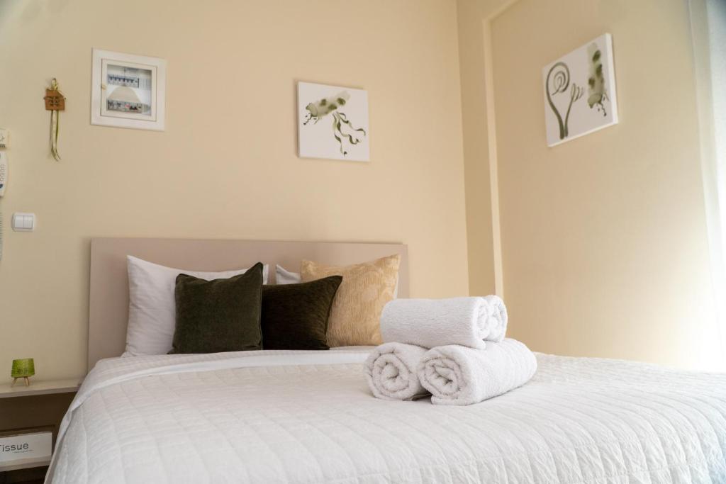 a bedroom with a white bed with towels on it at Stergios_Apartments 03 in Kozani