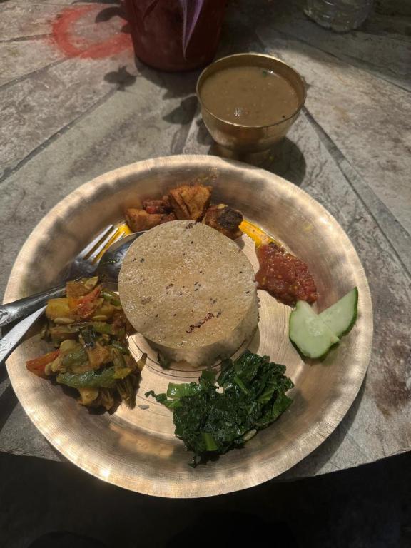 a plate of food with a sandwich and vegetables at Anne Homestay in Pokhara