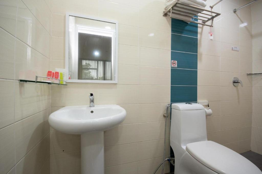 a bathroom with a sink and a toilet and a window at Capital O 89344 Labuan Avenue Hotel in Labuan