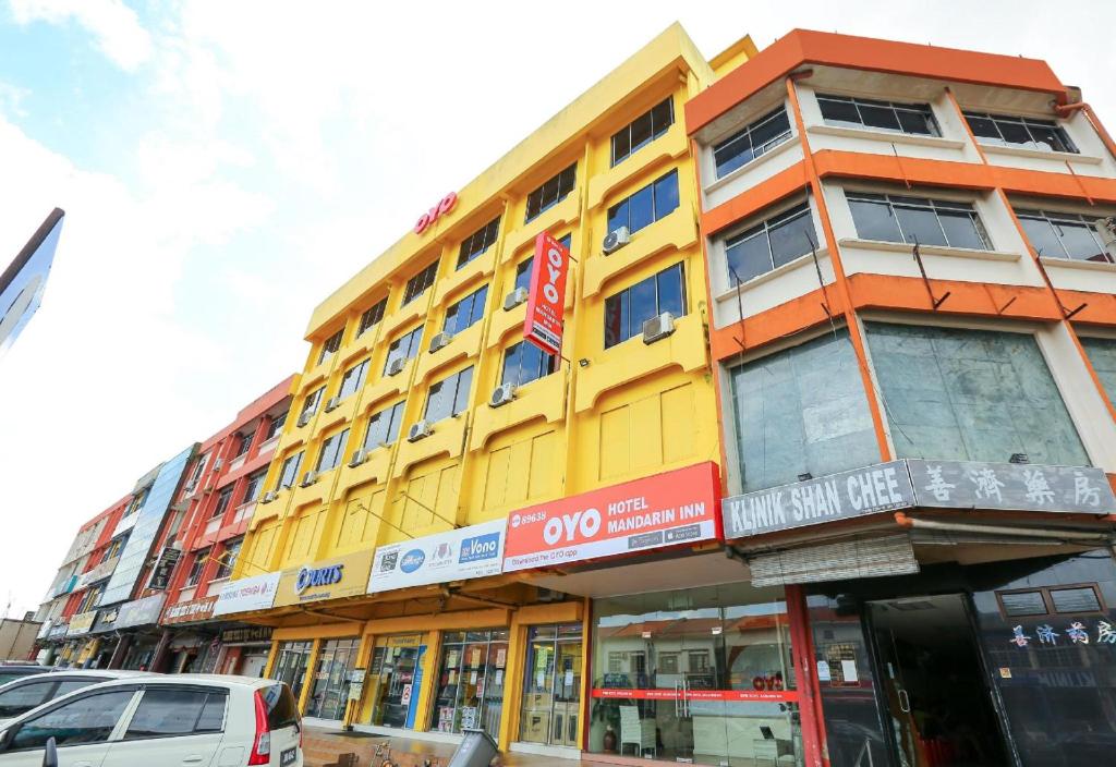 a yellow and orange building on a city street at Hotel O My Hotel in Segamat
